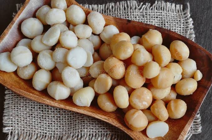 Roasted macadamia nuts in a wooden tray